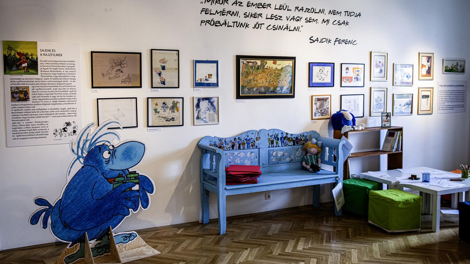 A tárlaton Sajdik Ferenc számos mesefigurája feltűnik, mint például a csokoládéért rajongó Gombóc Artúr