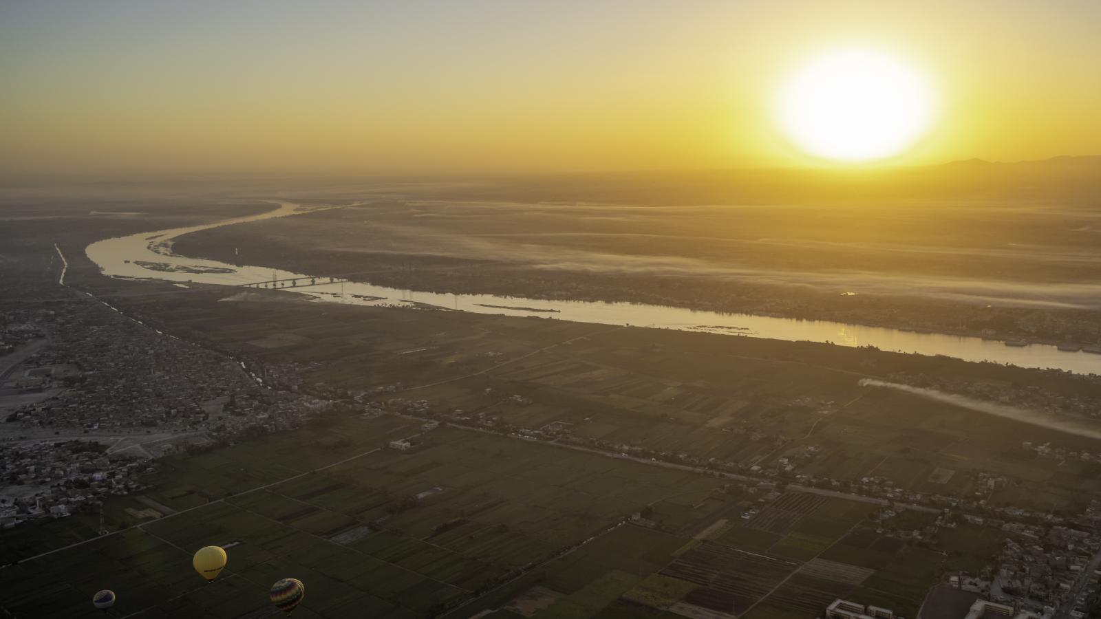 A Nílus folyó látképe egy hőlégballonból Luxor felett napkeltekor.