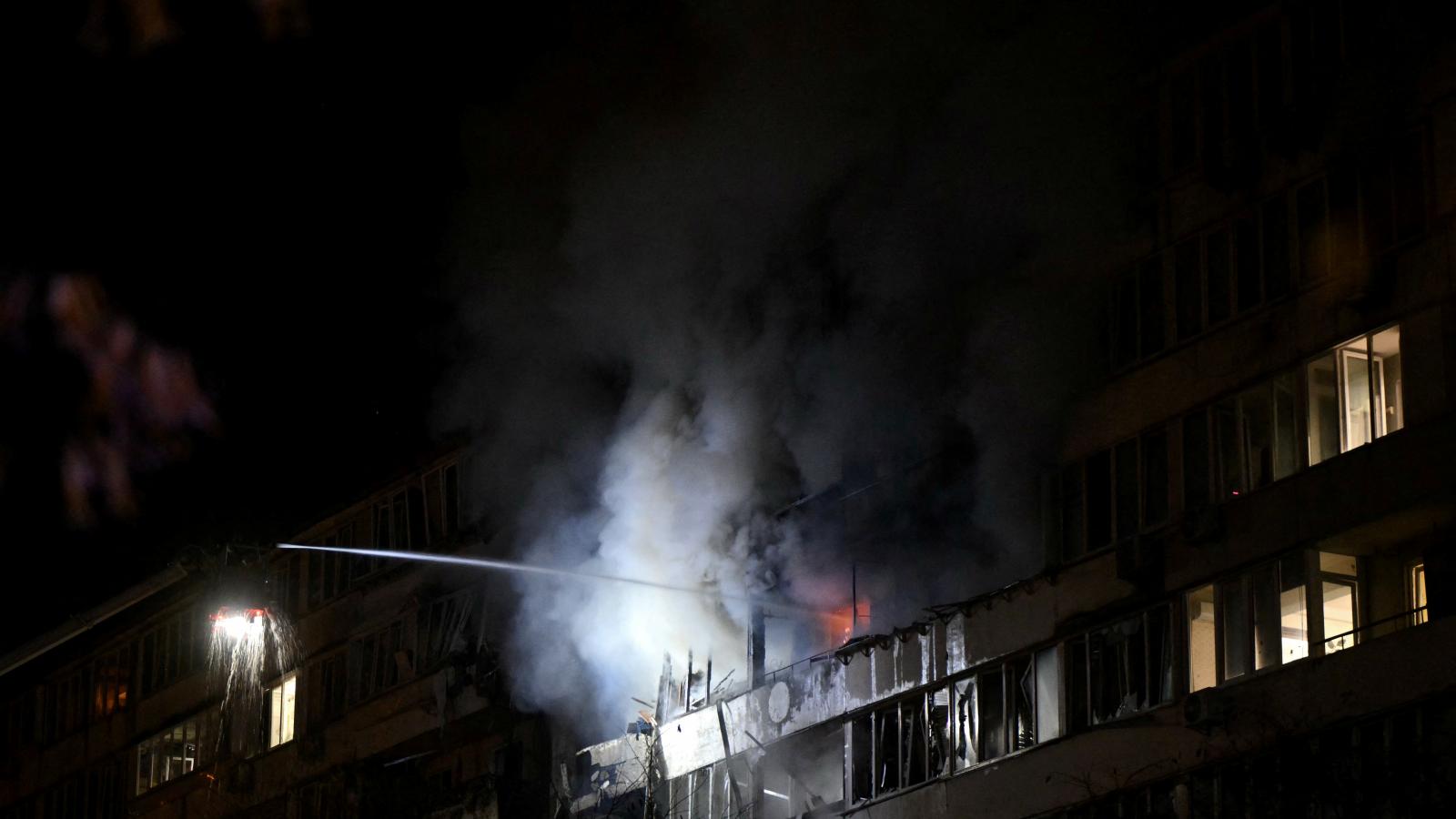 Ukrán mentőalakulatok oltják a kijevi légitámadást követően keletkezett lakóépület tüzet.