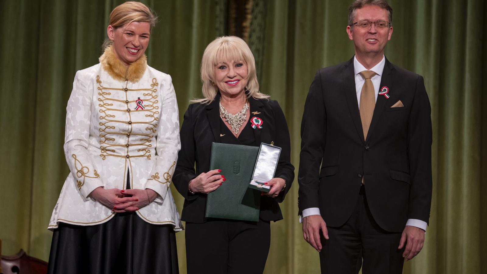 Zoltán Erika a Magyar Érdemrend Lovagkereszt polgári tagozat kitüntetéssel Varga-Bajusz Veronika államtitkár és Hankó Balázs miniszter között március 13-án 