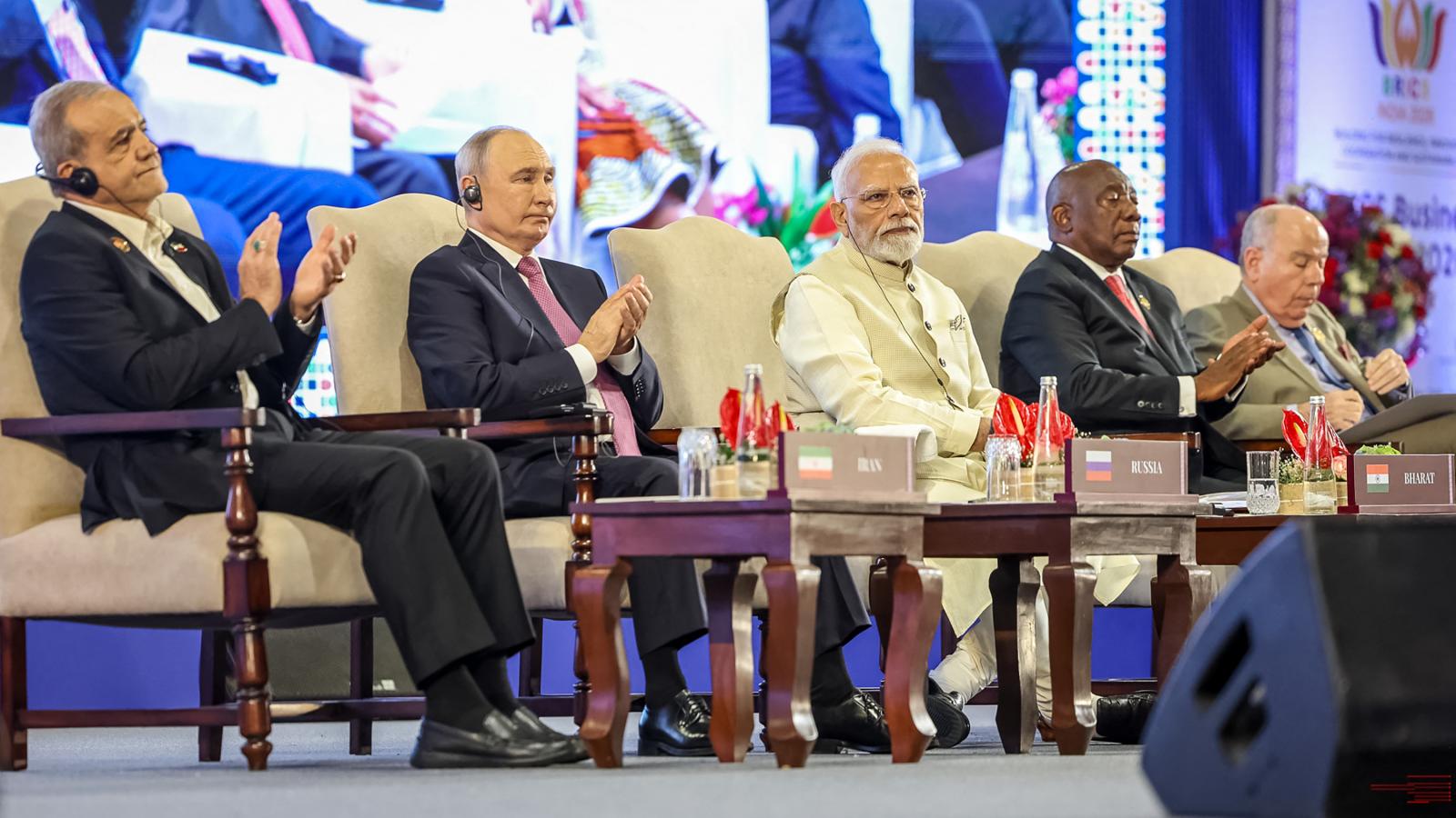 Maszúd Peszeskjan iráni elnök, Vlagyimir Putyin orosz elnök és Narendra Modi indiai miniszterelnök, Cyril Ramaphosa dél-afrikai elnökkel és Mauro Vieira brazil külügyminiszterrel az oldalán a BRICS-csúcs Üzleti Fórumán, Újdelhiben.