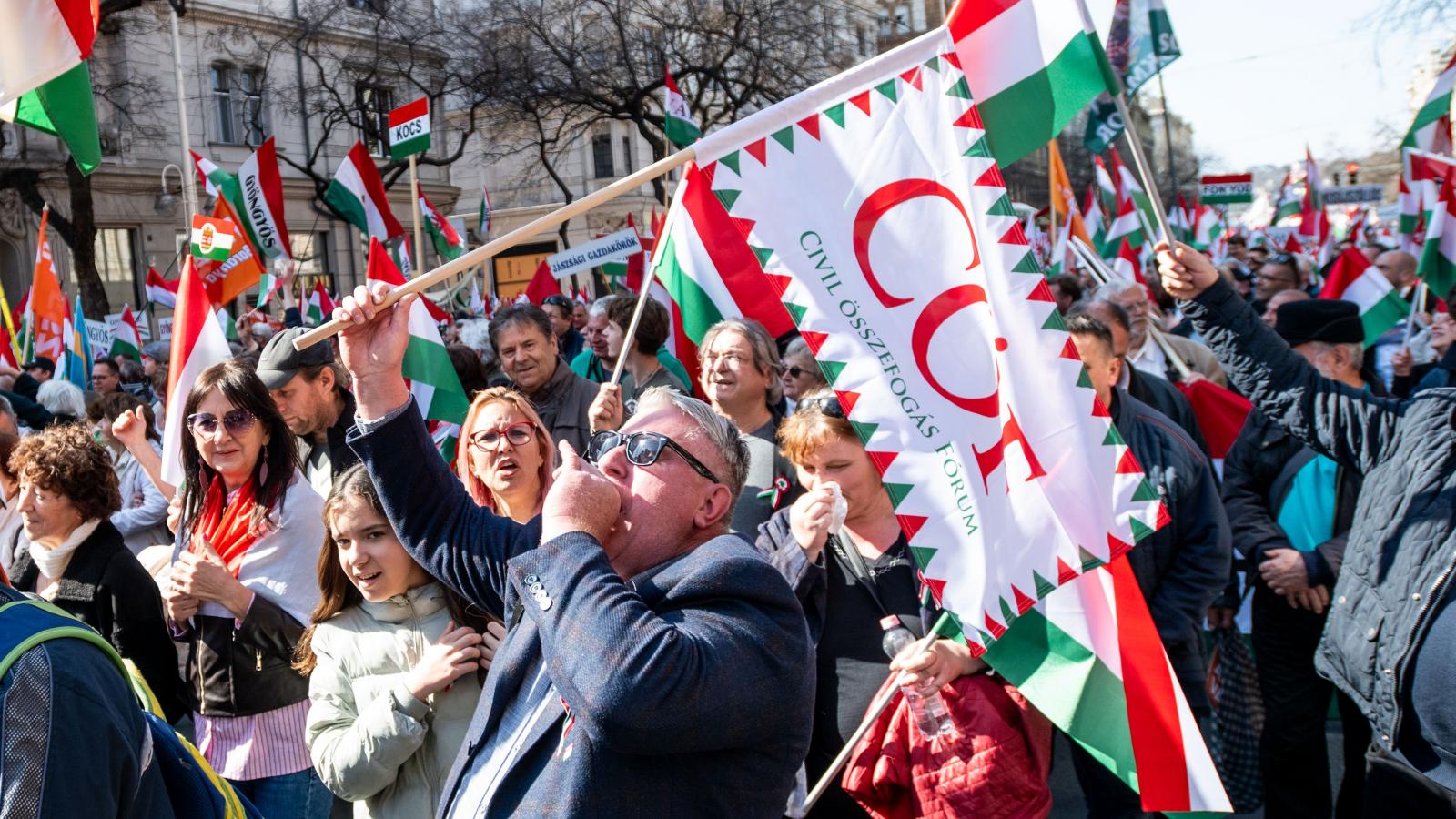 A Békemenet egyik résztvevője CÖF zászlóval sétál 2026. március 15-én