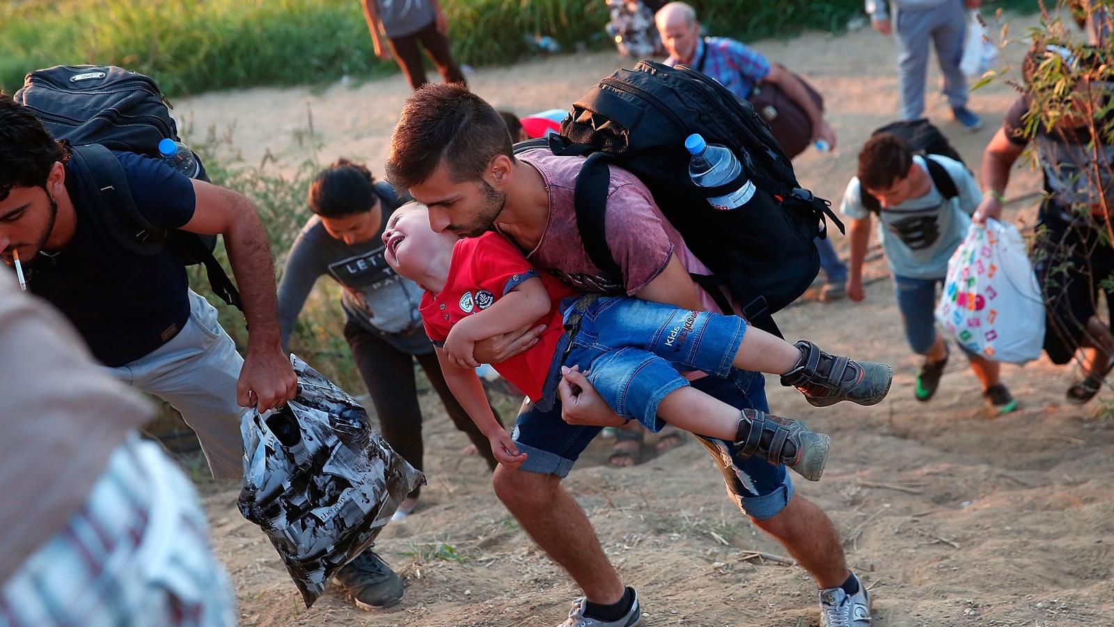 Ő még él -  Egy síró szíriai kisfiú, apjával a görög/macedón határon Fotó: Win McNamee / Getty Images