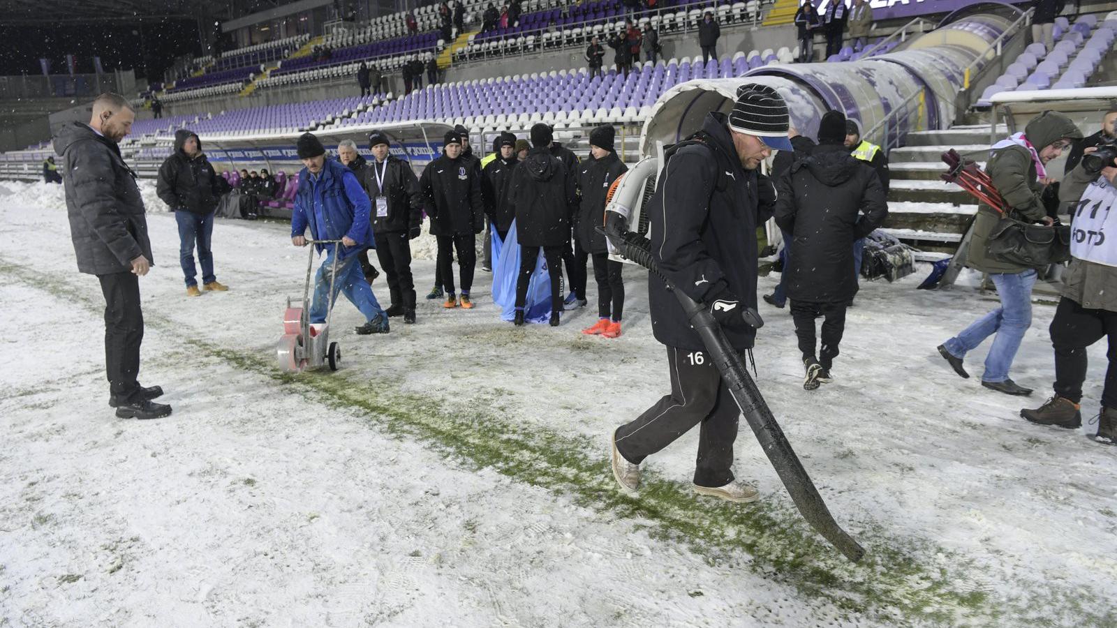 Karbantartók a behavazott pályán a Szusza Ferenc Stadionban 2018. február 20-án. Elmaradt az Újpest FC-Paksi FC mérkőzés, a labd