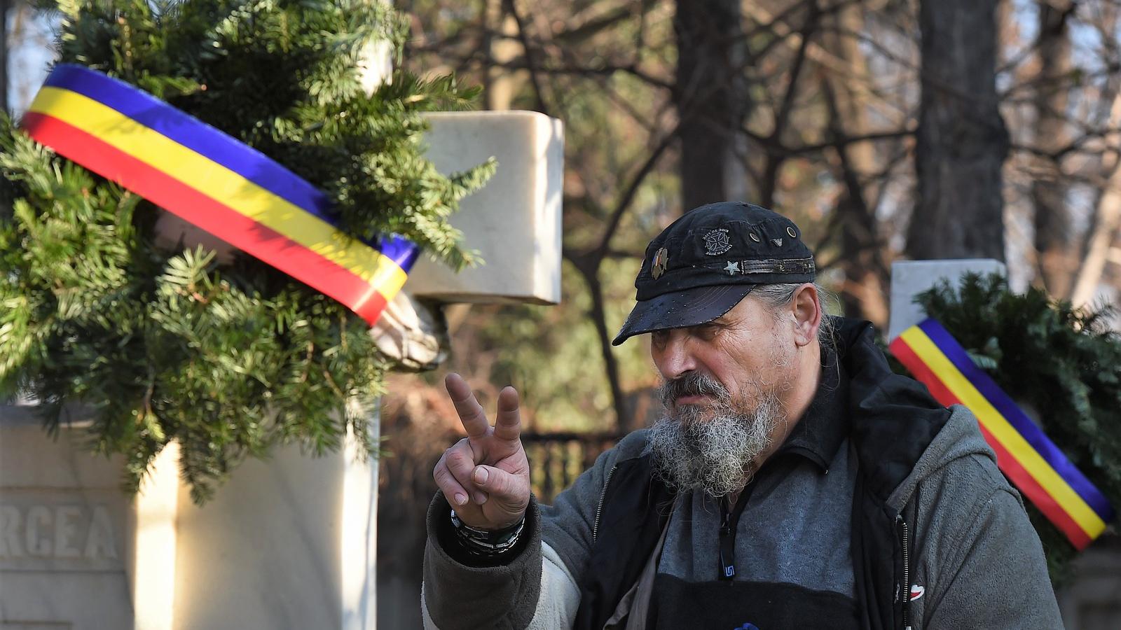 A győzelem jelét mutatja egy megemlékező a romániai forradalom áldozatainak bukaresti temetőjében, 2015 december 21-én Fotó: Dan