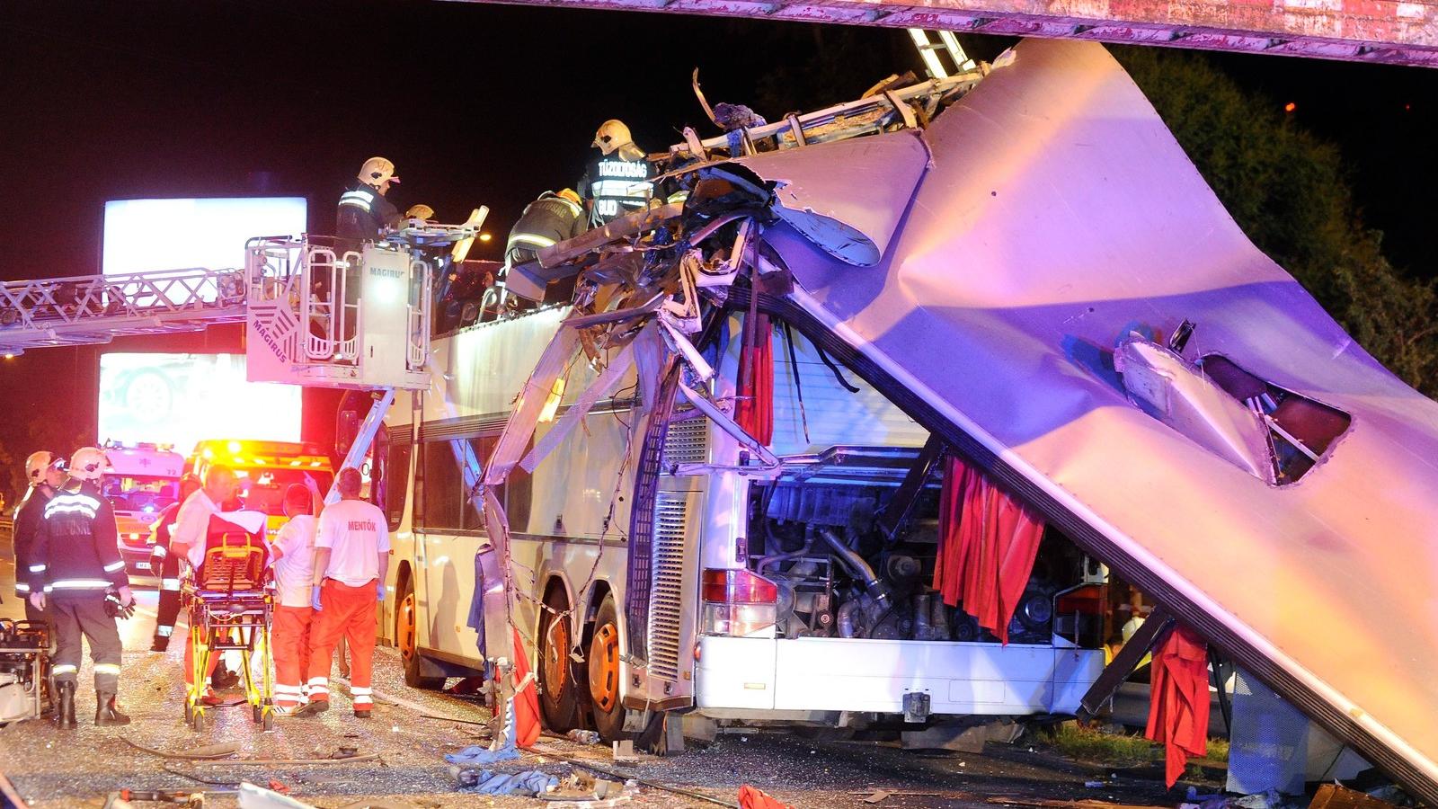 Tűzoltók, mentősök dolgoznak az ütközés után szétnyíló busz körül  Fotó: MTI/Mihádák Zoltán