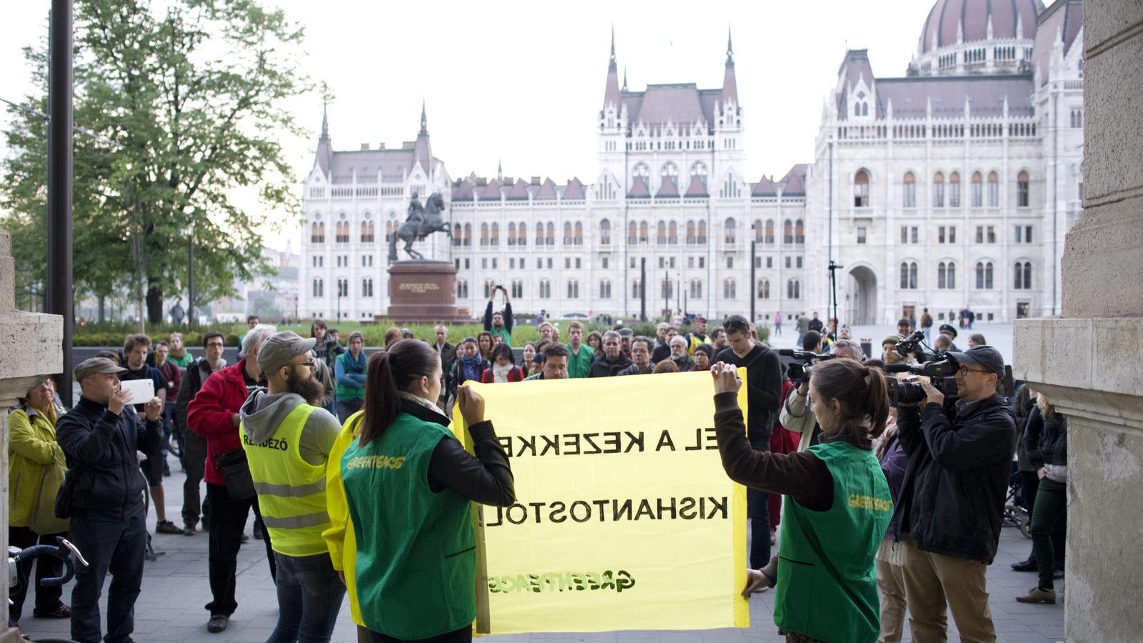 Greenpeace-aktivisták transzparenst tartanak a Vidékfejlesztési Minisztérium előtt a Kettős Mérce blog demonstrációján 2014. ápr