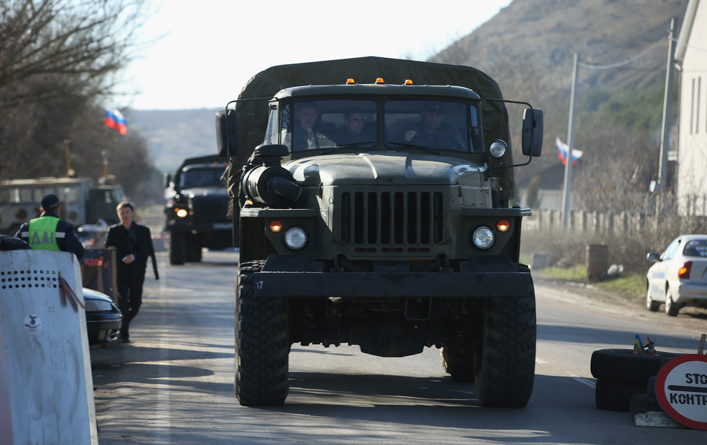 Orosz rendszámú katonai teherautók hajtanak át egy ellenőrzőponton a Krím-félszigeten, a Szevasztopol és Szimferopol közötti úton. Fotó: Sean Gallup/Getty Images