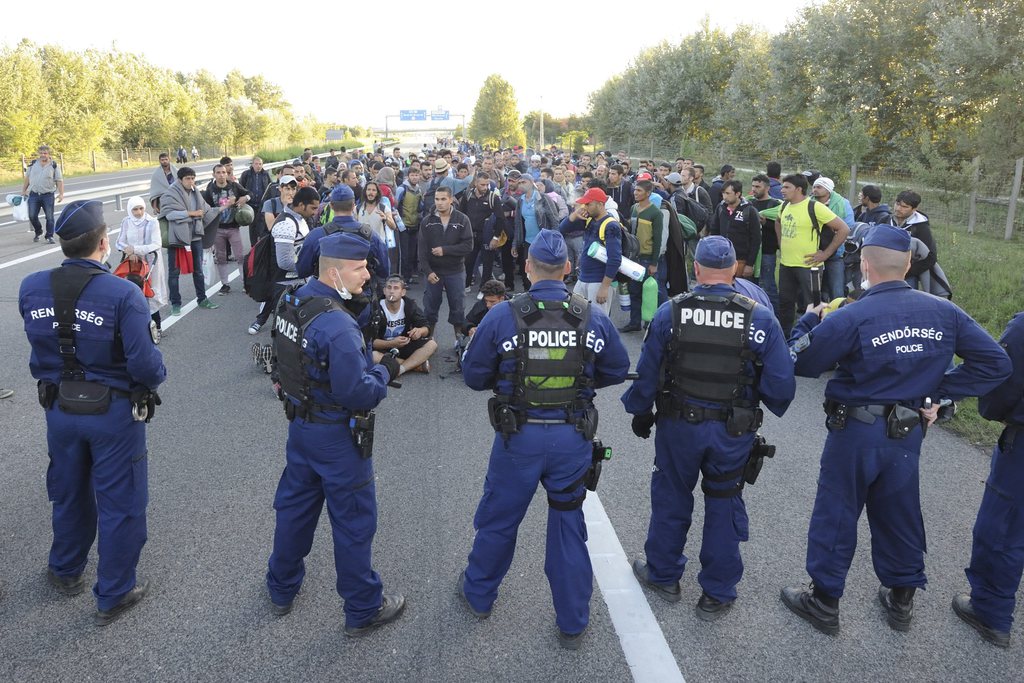 Migránsok állnak szemben rendőrökkel az M5-ös autópályán Röszke közelében 2015. szeptember 7-én. Közel ezer migráns kijutott a röszkei gyűjtőpontról, miután áttörtek a rendőri élőkordonon. Az emberek egy része elindult Budapest felé az M5-ös autópályán. MTI Fotó: Kelemen Zoltán Gergely